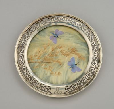 A bottle trivet with sterling silver mount, with grasses and butterfly decor, c. 1900 - Jugendstil e arte applicata del 20 secolo