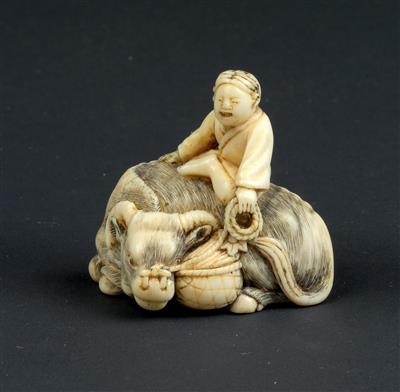 Netsuke eines Knaben auf einem liegenden Rind sitzend - Asiatika