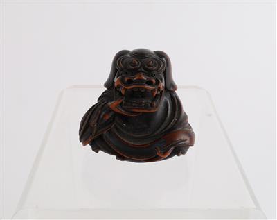 Netsuke eines Sitzenden mit Löwenmaske, - Antiquitäten