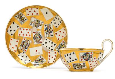 A teacup and saucer decorated with playing cards, - Vetri e porcellane