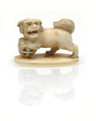 An ivory netsuke of a shishi leaning both its front paws on a ball - Arte asiatica