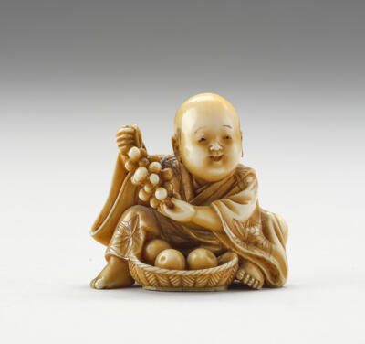 Netsuke eines Mannes mit Weintrauben und Früchtekorb, Japan, Meiji Periode (1868-1912), signiert Komin, - Asiatische Kunst